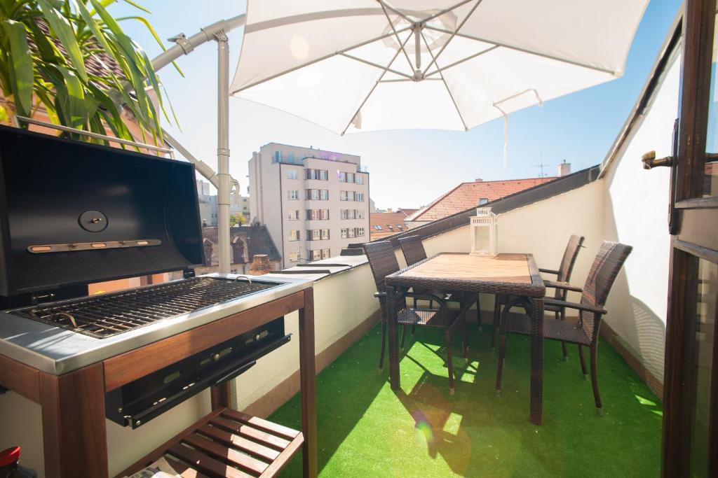 a balcony with a table and an umbrella on a balcony at Blue Lotus Apartments in Bratislava