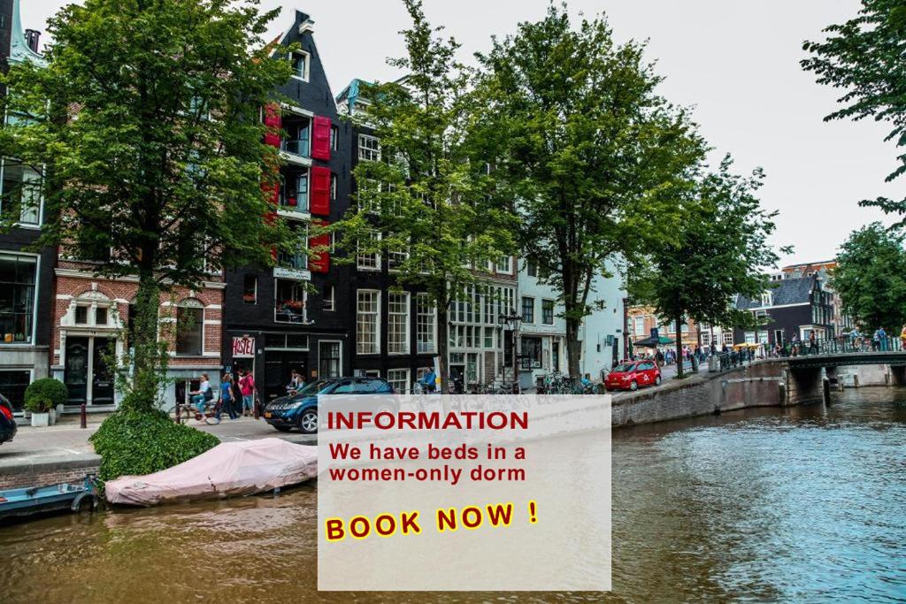 ein Schild neben einem Fluss in einer Stadt in der Unterkunft International Budget Hostel City Center in Amsterdam