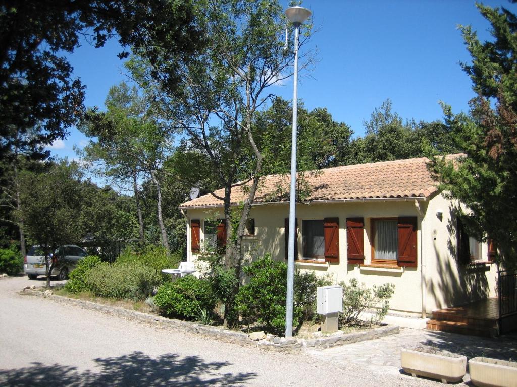 a small house with a light pole next to a street at Bungalow Claret in Vacquières