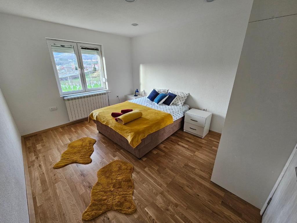 1 dormitorio con 1 cama con sábanas amarillas y suelo de madera en Ethno Village Adžić en Mojkovac