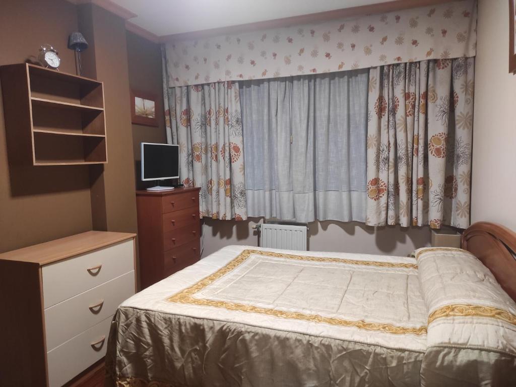 a bedroom with a bed and a dresser and a window at Habitación Centro Pontereas in Ponteareas