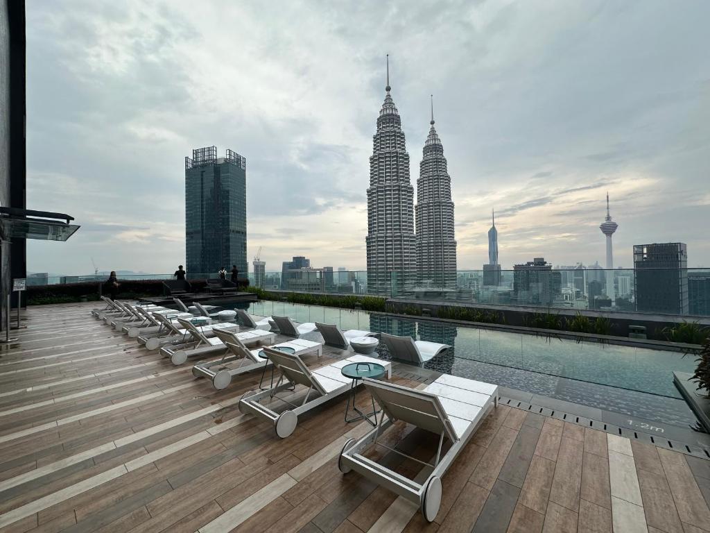 una fila di sedie a sdraio sul tetto di un edificio di Skyline Homes by Star Residences KLCC a Kuala Lumpur