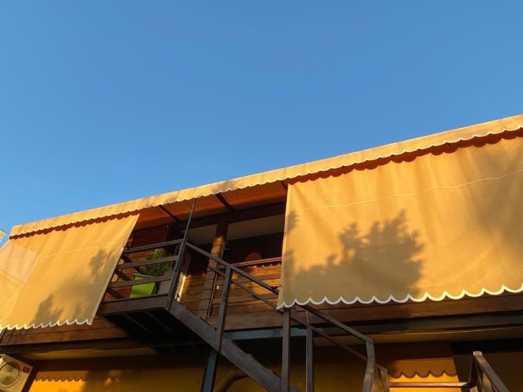a building with a balcony and a blue sky at Hostel Avetaia in Santa Rosa de Calamuchita