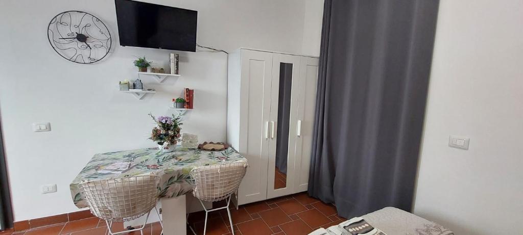 a room with a table and a clock on the wall at Bed And Breakfast A CASA DI LEO in Tarquinia