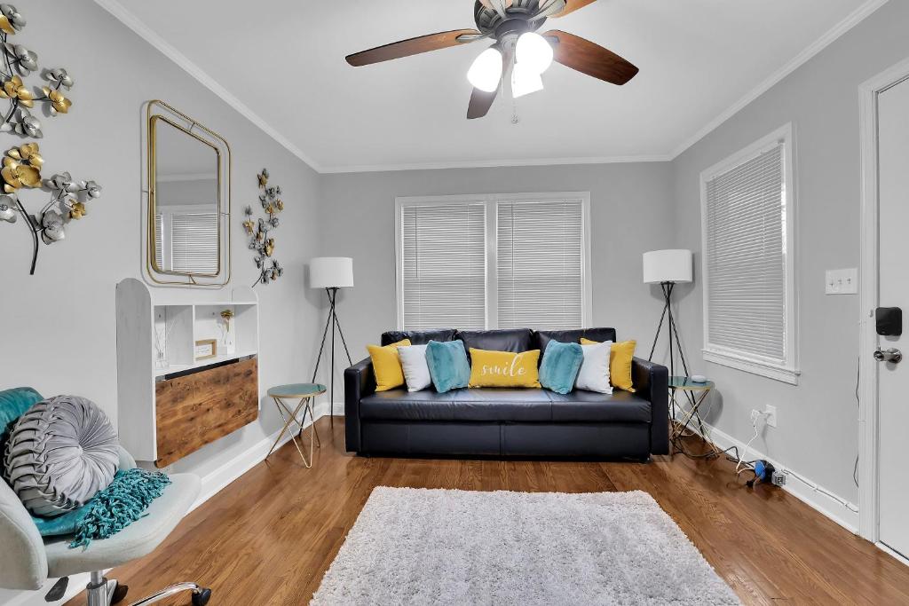 een woonkamer met een bank en een plafondventilator bij GoodLiving: Serenity in Atlanta