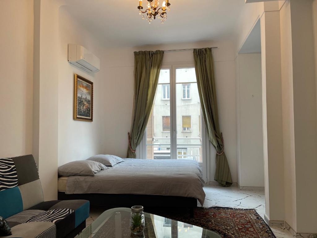1 dormitorio con cama y ventana grande en IMPERIA 2, en Niza