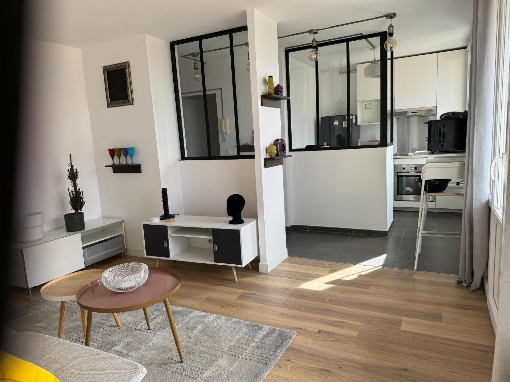 uma sala de estar com paredes brancas e uma mesa e um sofá em Vitry em Vitry-sur-Seine