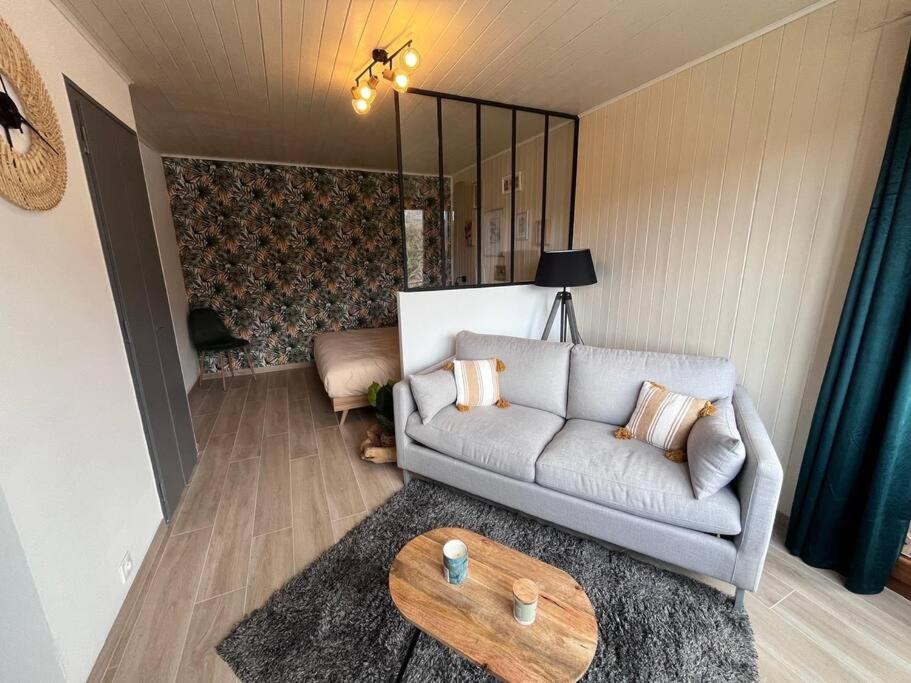 - un salon avec un canapé et une table dans l'établissement Le Tropical, à Bellegarde-sur-Valserine