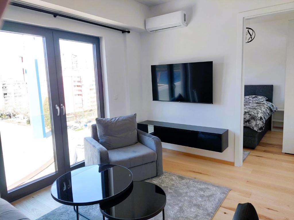 un soggiorno con divano, tavolo e TV di The Stadium View Apartment a Sarajevo