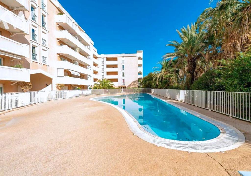 a swimming pool in front of a apartment building at Le Victoria-Centre ville-Piscine-Parking privé-Wi-Fi in Hyères