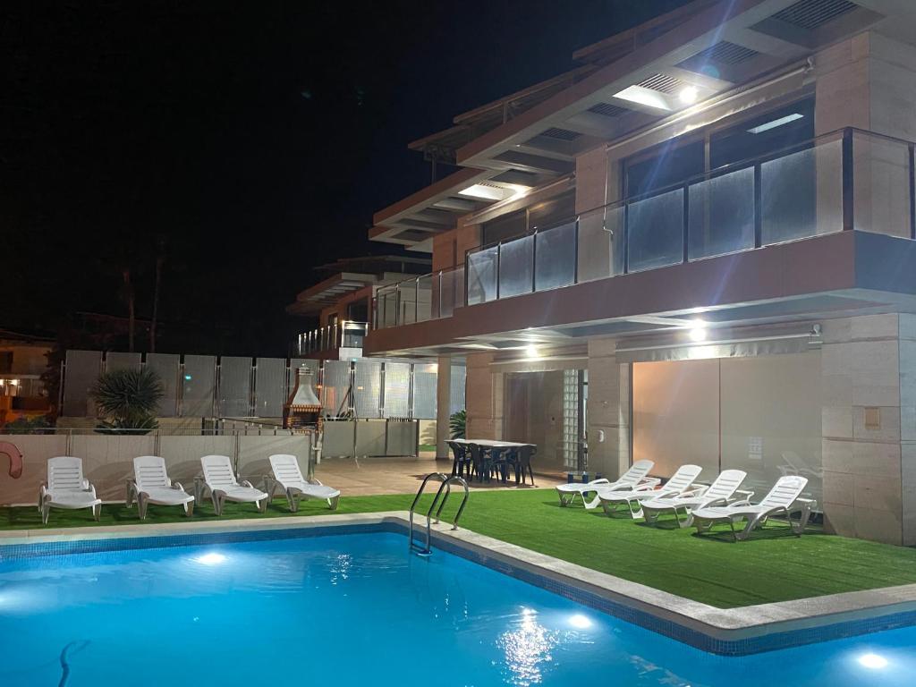 una casa con piscina di notte di Altos Golf Bahía Benidorm a Finestrat