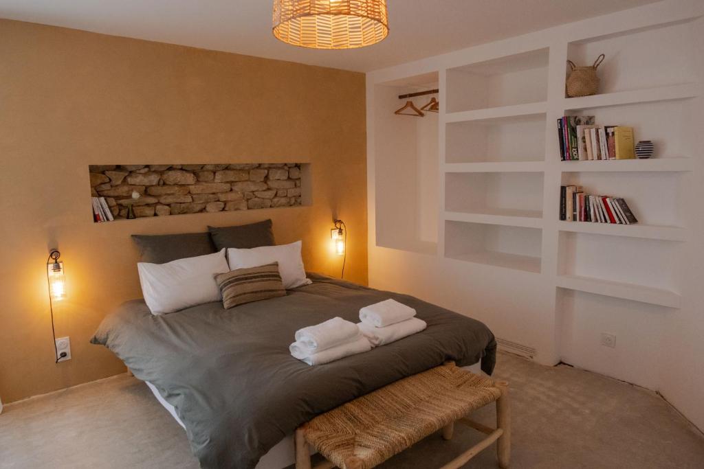 una camera da letto con un letto con due asciugamani sopra di L'Atelier des Vignes a Saint-Pantaléon