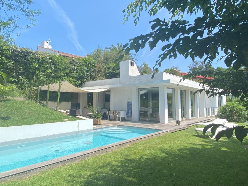 une maison avec une piscine dans la cour dans l'établissement Villa: Piscine, proche Centre & Mer, à Saint-Jean-de-Luz