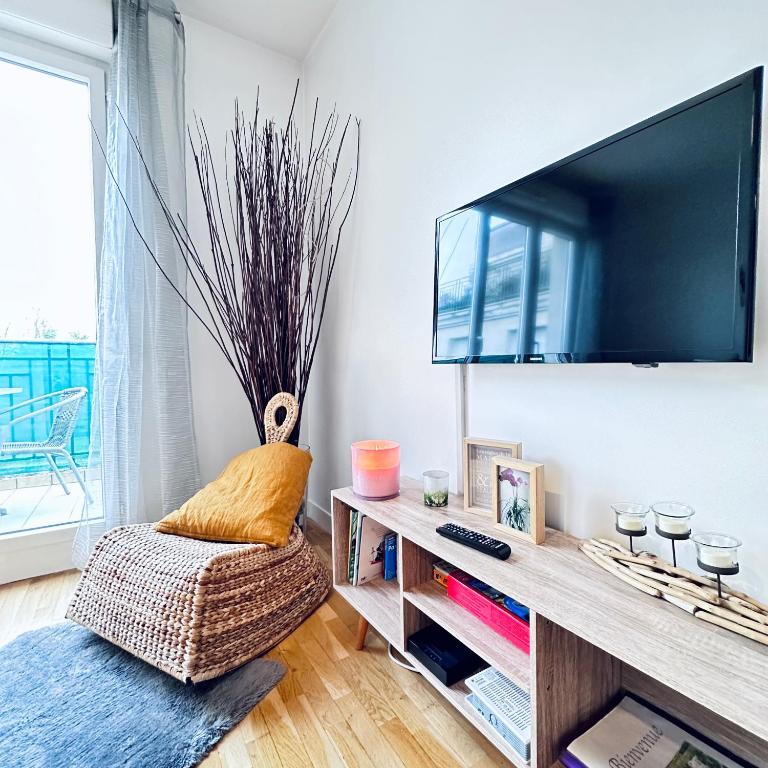 un salon avec une télévision à écran plat sur un mur dans l'établissement Sweet apartment in front of Disneyland's castel, à Montévrain