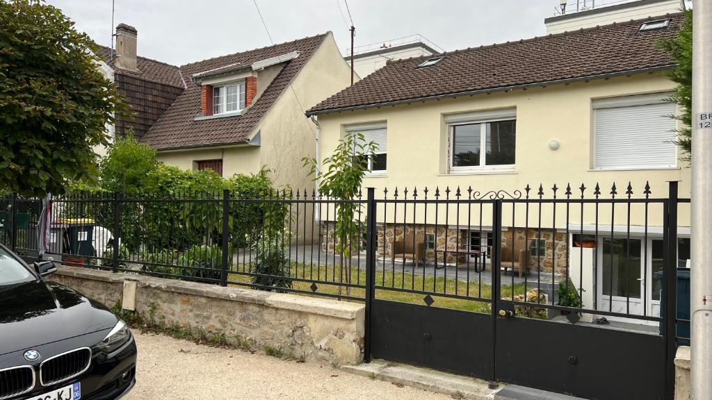 une clôture noire devant une maison dans l'établissement Maison individuelle à louer, à Villemomble