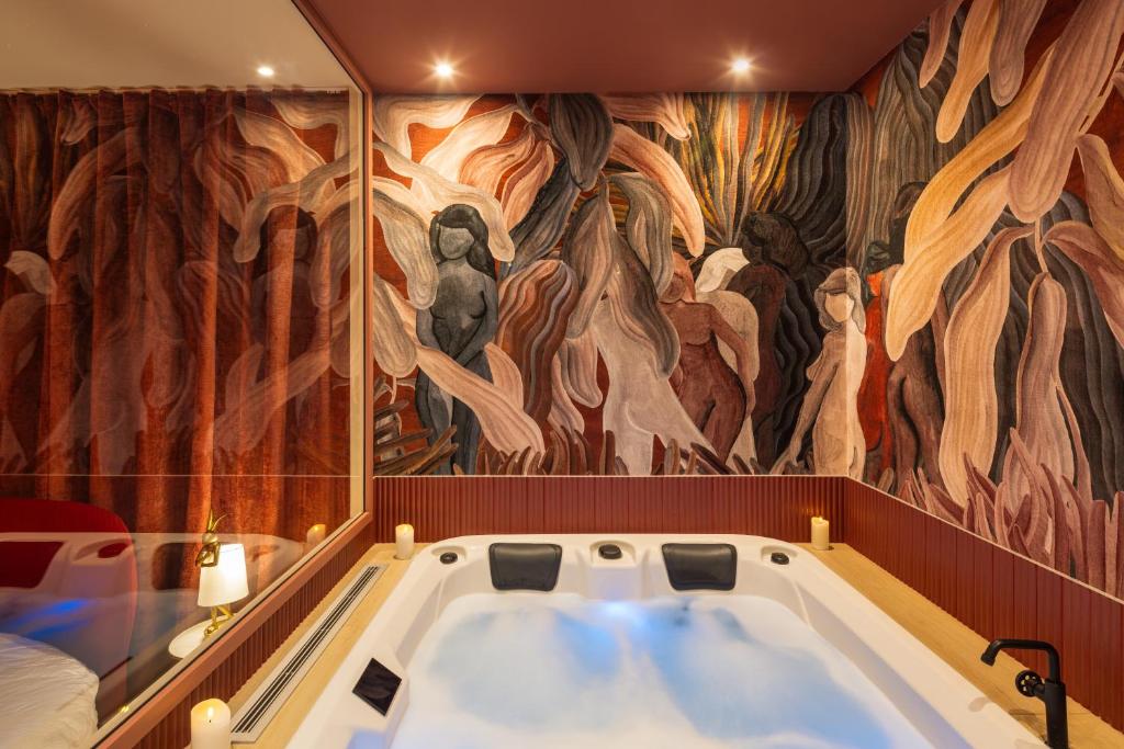a bath tub in a room with a mural at Mountain Love in Saint-Claude