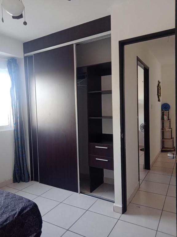 a bedroom with a closet with a bed and a mirror at PH OLAS TOWERS FRONT. PLAYA LA BARQUETA in Chiriquí
