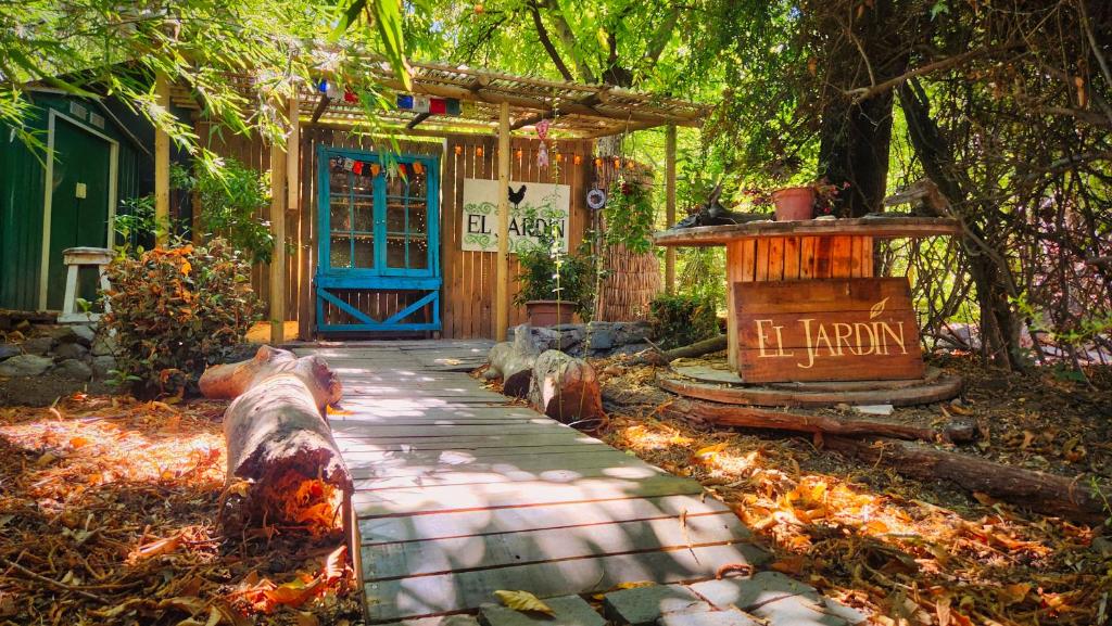 聖阿方索的住宿－El Jardin, Eco Cabañas Boutique，一条带蓝色门的房子前的走道