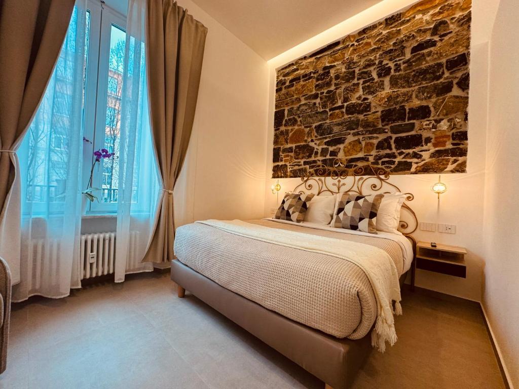 a bedroom with a bed with a stone wall at Lina suites & rooms in La Spezia