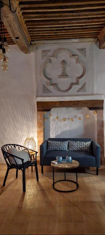 un salon avec un canapé bleu et une table dans l'établissement Studio Isaline RDC, à Saint-Ambroix