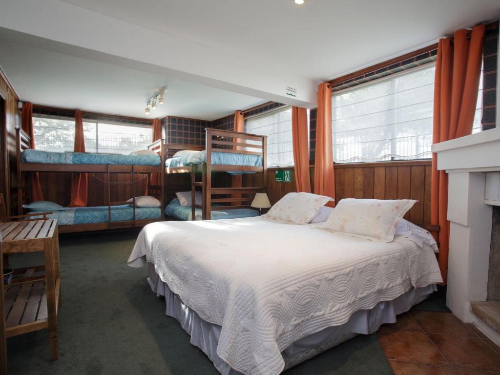a bedroom with a bed and two bunk beds at Sandy Point B&B in Punta Arenas