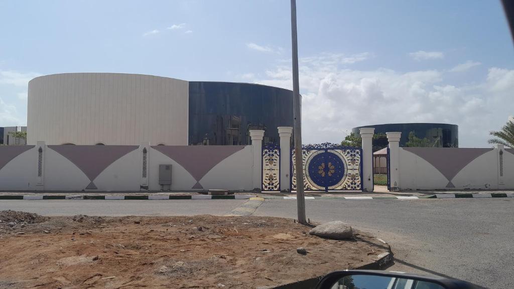 un bâtiment avec un panneau sur le côté d'une route dans l'établissement IDMAN RESIDENCE, à Ambouli