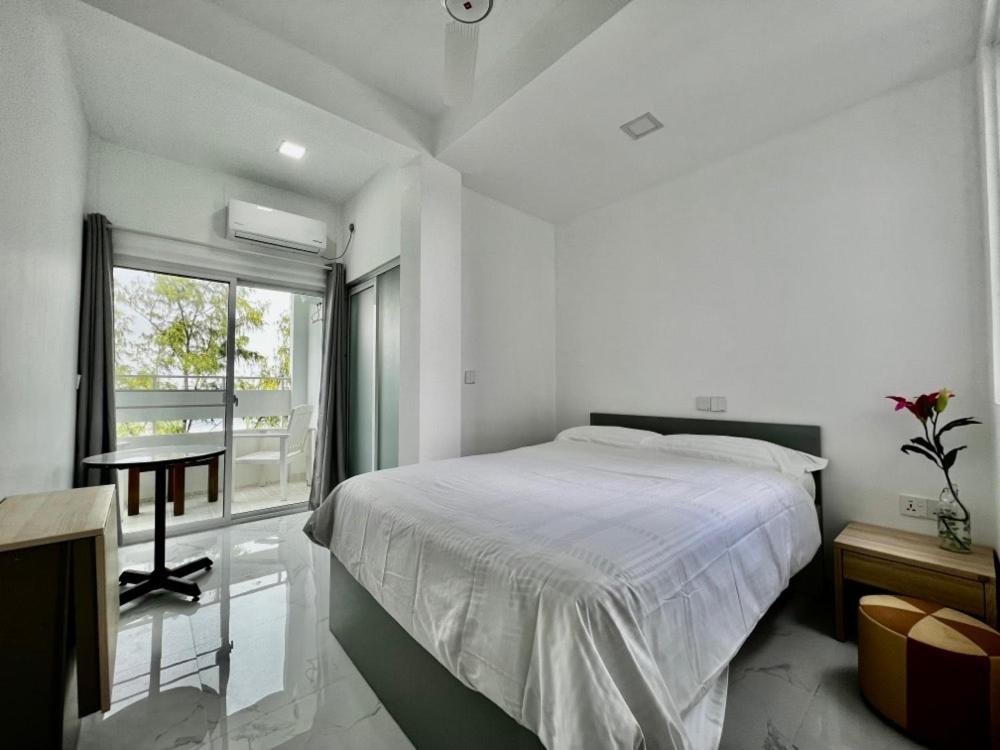a bedroom with a bed and a desk and a window at Dhonveli Stay in Hulhumale