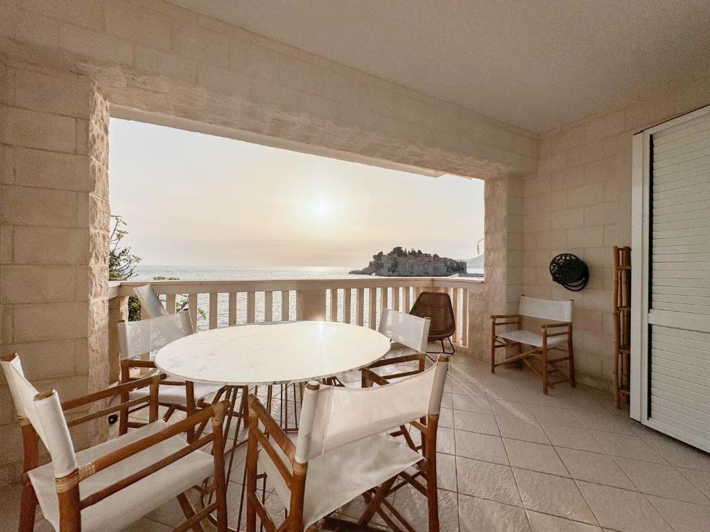 d'une table et de chaises sur un balcon avec vue sur l'océan. dans l'établissement Apartment Radovic, à Sveti Stefan