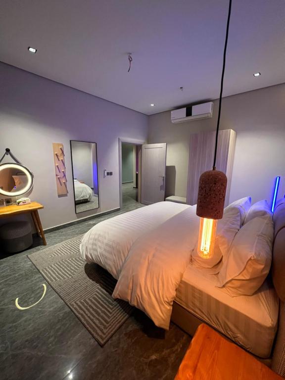 una camera da letto con un grande letto con una lampada di Timber suites تمبر سويتس a Riyad