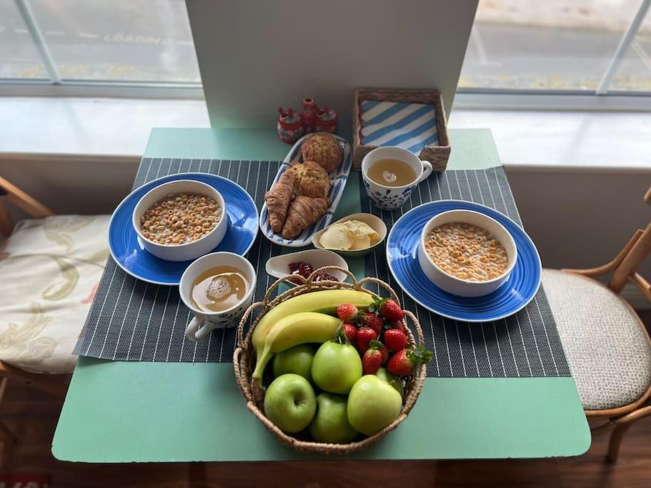 une table avec des assiettes de nourriture et des bols de fruits dans l'établissement Your Own Home İn The Heart Of The City, à Dublin
