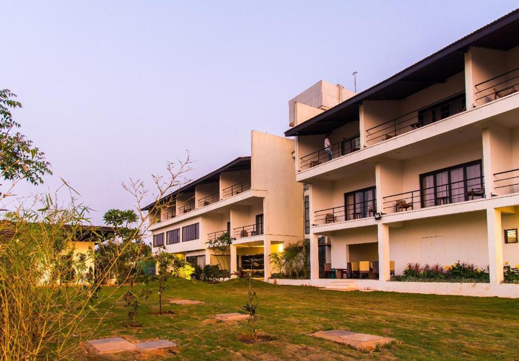 an apartment building with a lawn in front of it at Dandeli Kali River Stay in Dandeli
