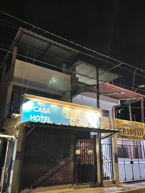 um sinal na frente de um hotel à noite em Sand house em Máncora