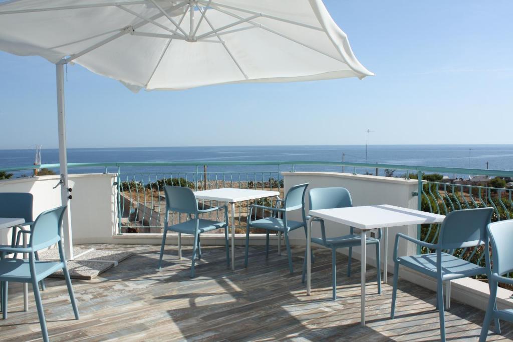 a patio with tables and chairs and an umbrella at B&B Alalama in Polignano a Mare