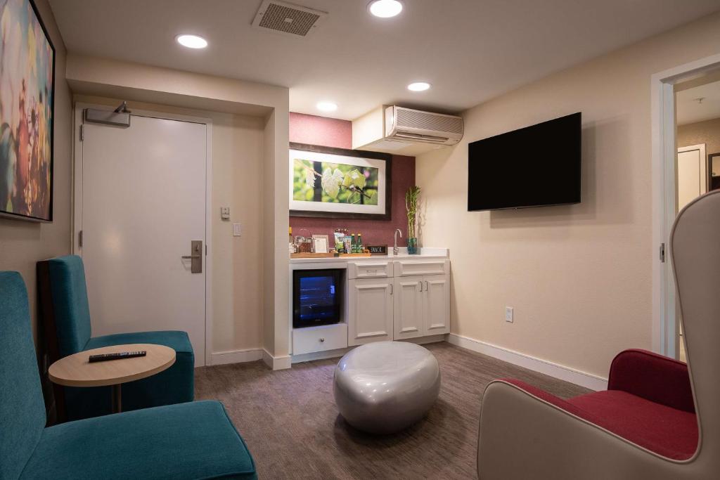 ein Wohnzimmer mit Fernseher und Tisch und Stühlen in der Unterkunft Hilton Garden Inn Calabasas in Calabasas
