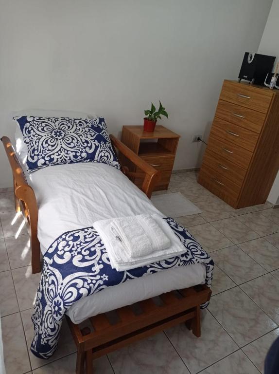 Cette chambre comprend un lit avec des draps bleus et blancs et une commode. dans l'établissement Bed & Breakfast San Rafael, à San Rafael