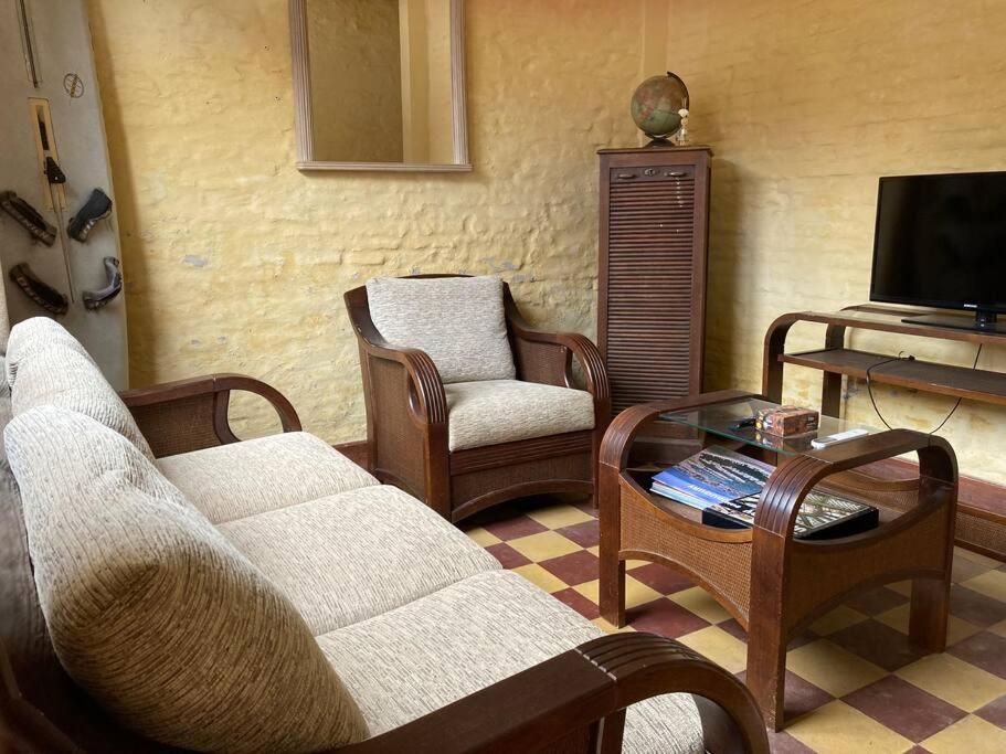 a living room with a couch and chairs and a tv at La casita de Morgan in Mercedes