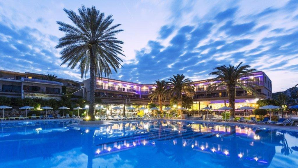 einem großen Pool mit Palmen vor einem Gebäude in der Unterkunft Cathrin Hotel in Faliraki