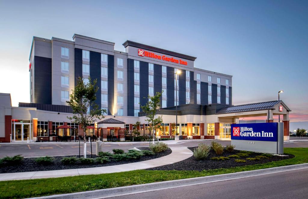 un bâtiment d'hôtel avec un panneau devant lui dans l'établissement Hilton Garden Inn Winnipeg South, à Winnipeg