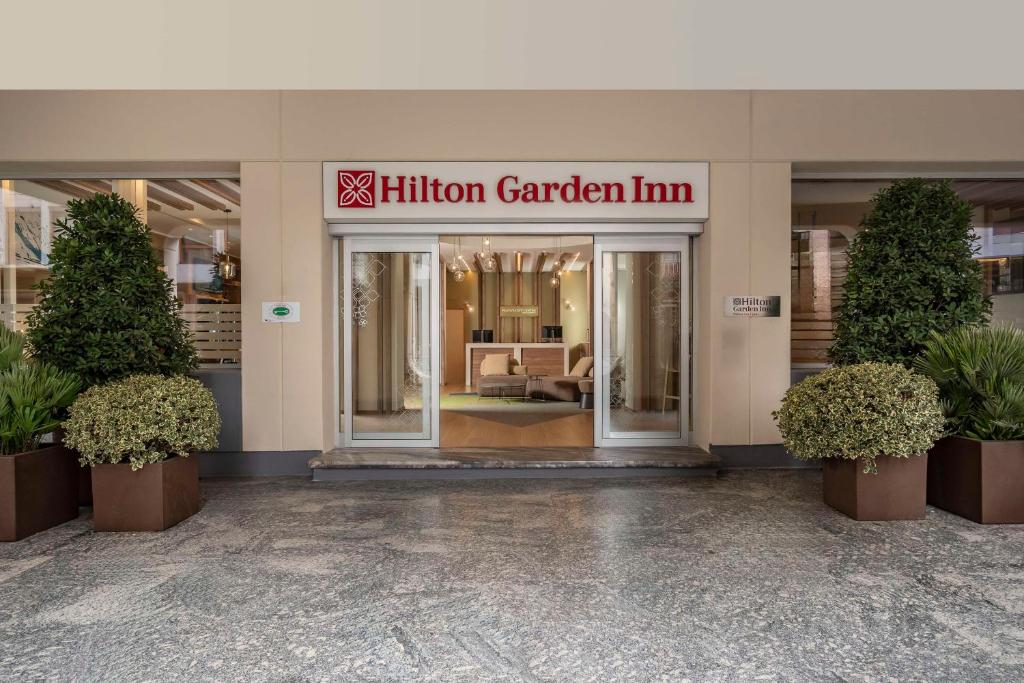 Hilton Garden Inn Padova City Centre في بادوفا: مدخل لمبنى فيه مليون نزل حديقة
