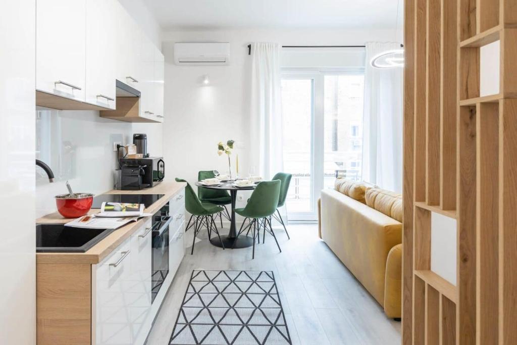 a kitchen with a couch and a table with chairs at Lux Nest Extra City Apartment URBAN STAY in Zagreb