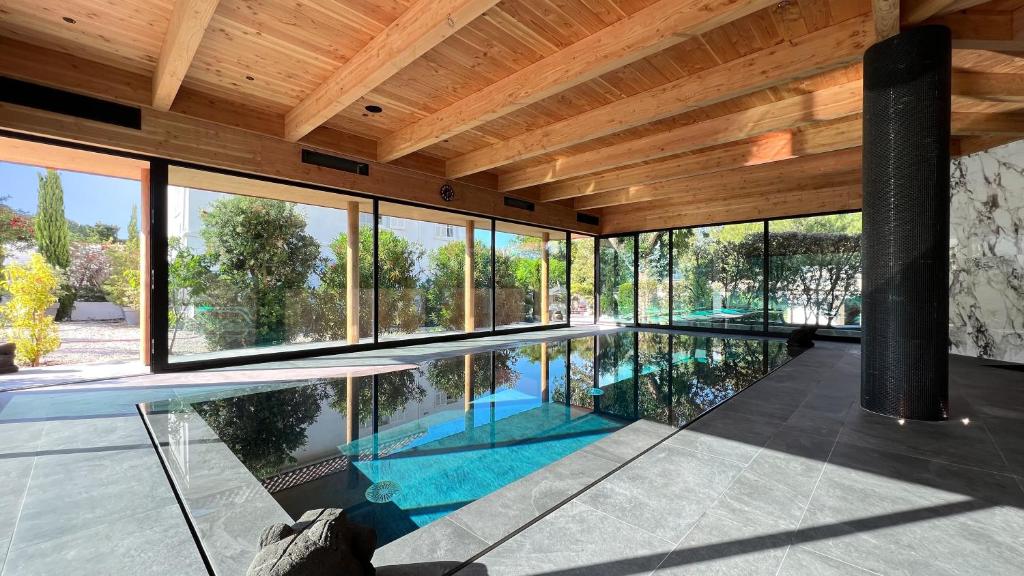 an indoor swimming pool in a house with windows at Campo Di Fiori, Maisons de Charme in Calvi