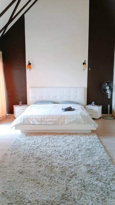 a bedroom with a white bed and a rug at Silverpart Resort Fraser Hill C3-6-2 Forest View High Floor No lift in Bukit Fraser