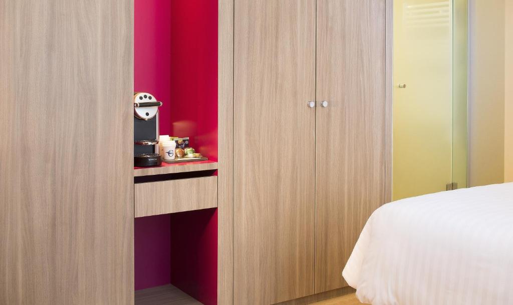 1 dormitorio con cama blanca y pared roja en Oceania Rennes, en Saint-Grégoire