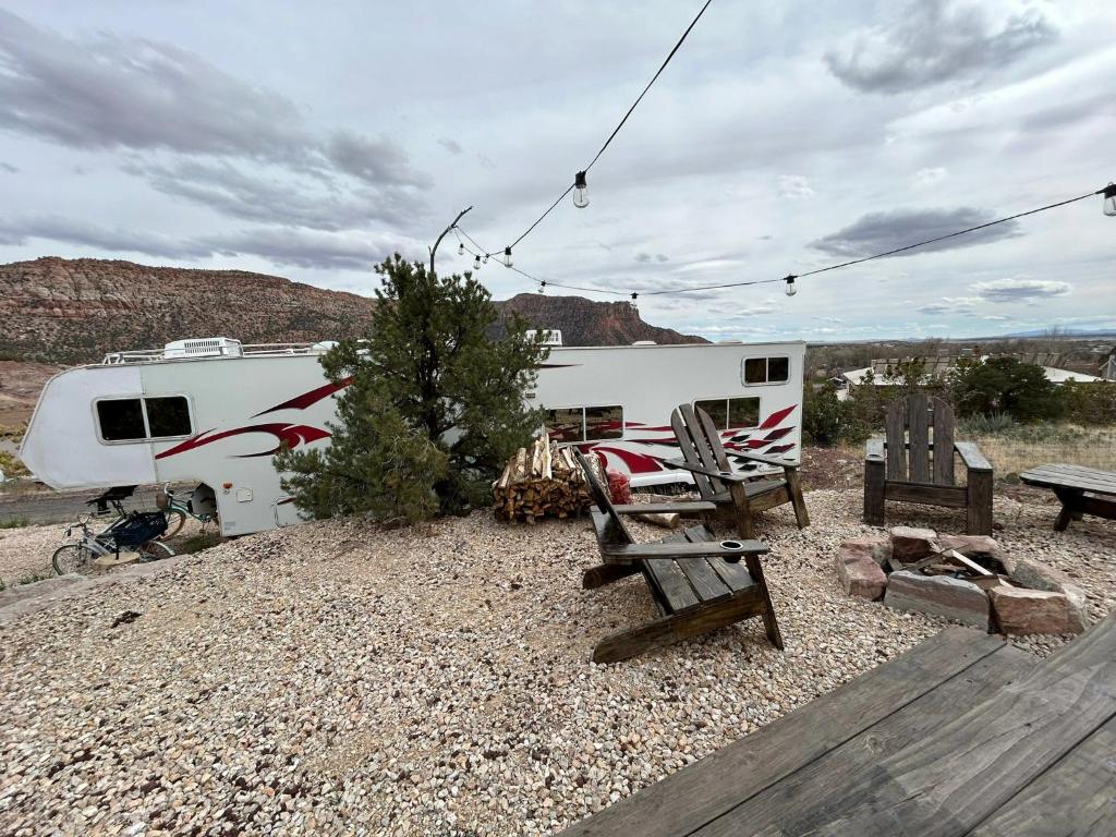 a rv parked in the desert with a table and chairs at Retreat (rinconcito) in Hildale