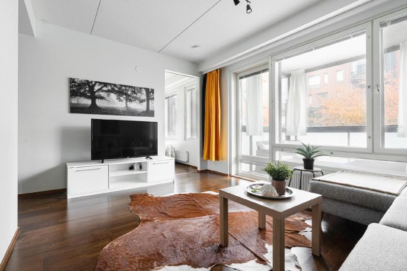 a living room with a couch and a tv at City flat with a sauna & balcony in Helsinki