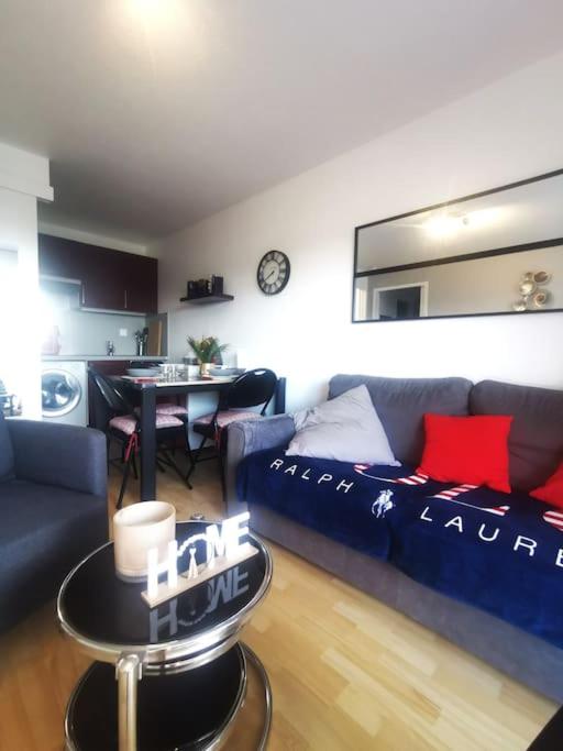 un salon avec un canapé bleu et une table dans l'établissement L'Orée du marais, T2 avec balcon, 350m de la plage, à Villers-sur-Mer