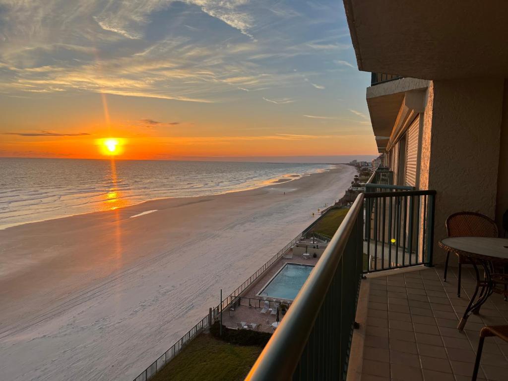a balcony with a view of the beach at sunset at Ponce Inlet Florida Breathtaking Oceanfront Penthouse Villa! in Ponce Inlet