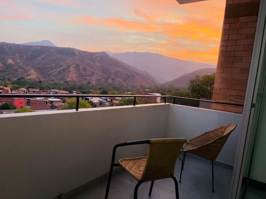 a balcony with two chairs and a view of mountains at ¡Vista Increíble Apartamento Tamarindo! in Santa Fe de Antioquia