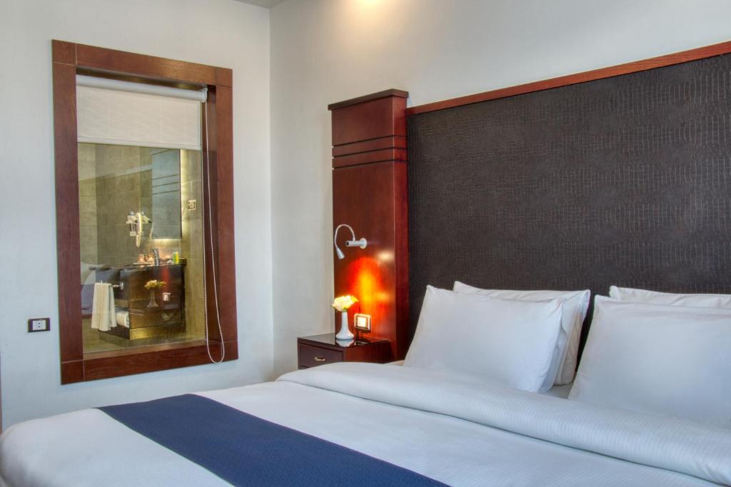 Un dormitorio con una cama grande con un cabecero grande. en Torino Hotel Amman, en Amán