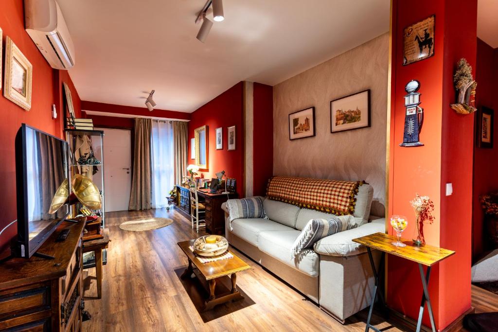 阿尔卡拉德荷那利斯Apartamento Mikaela Alcalá de Henares的客厅设有红色的墙壁和沙发